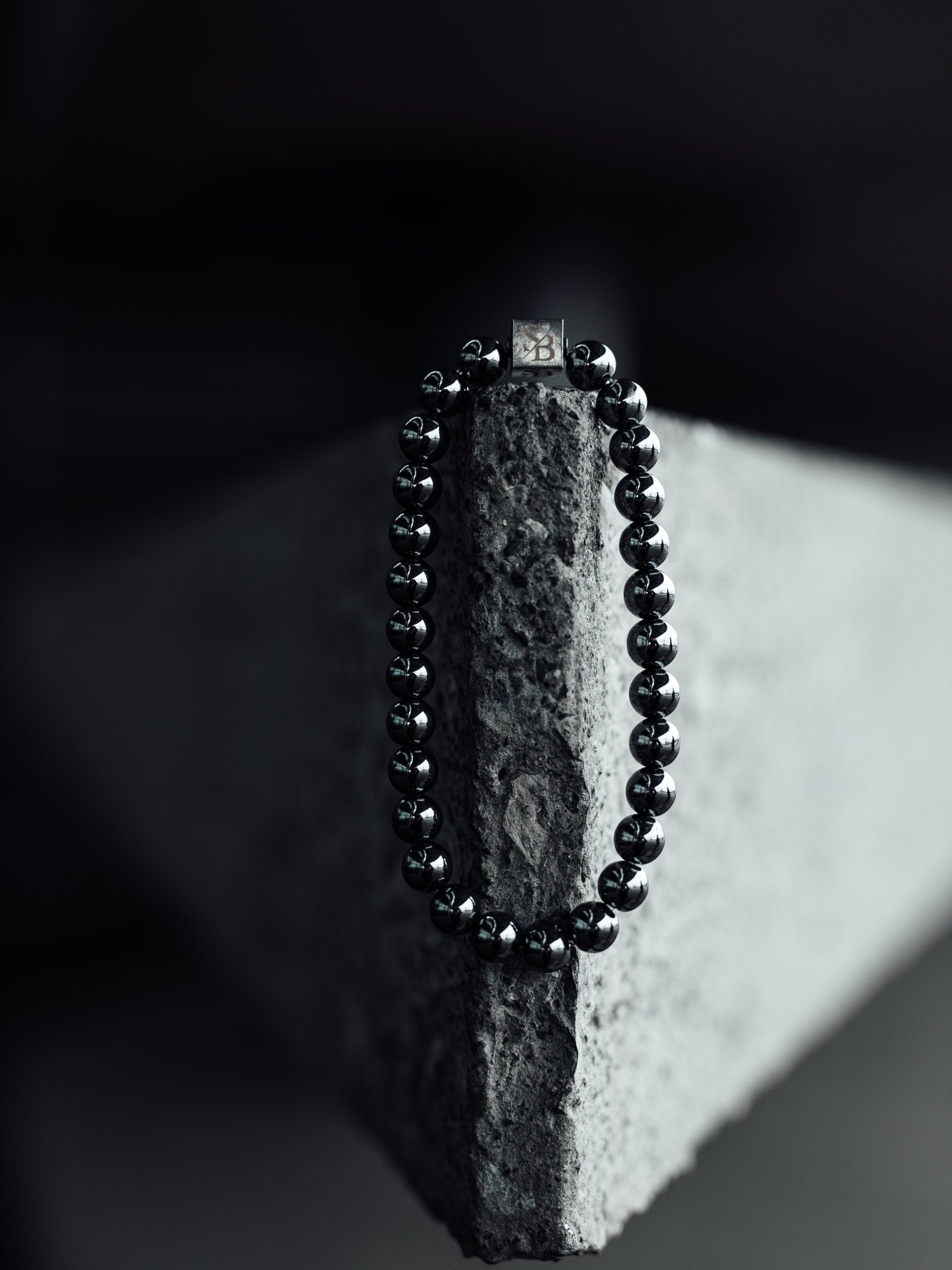 De Superior collectie van Stoney bracelets heeft heren armbanden met 925 zilveren kralen. Op de foto zie je een hematiet armband met logobead.