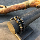 Een paar Stoney-armbanden gemaakt met Afrikaanse stenen (8 mm), zittend op een houten blok, gemaakt met Afrikaanse Jaspis-stenen.