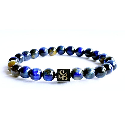 Verken de magie van de Blue Tiger Eye armband, gemaakt van betoverende blauwe tijgeroog stenen. Laat je meeslepen door de diepe, mysterieuze blauwe tinten van deze natuursteen, terwijl je geniet van de krachtige uitstraling van dit prachtige sieraad.