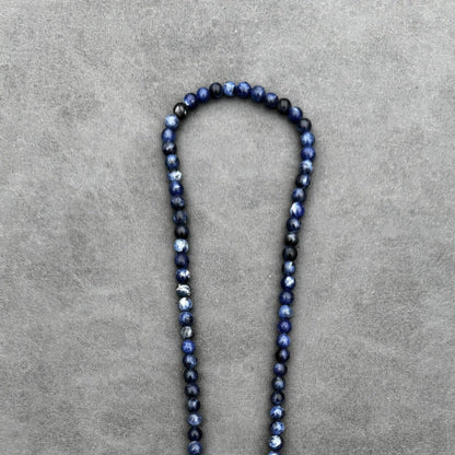 De Royal Lapis Necklace van Stoney Bracelets is een opvallend sieraad met kleine, ronde blauwe kraaltjes van 6 mm die subtiel van kleur verschillen tegen een grijze achtergrond. Hierdoor ontstaat een prachtig kleurverloop dat doet denken aan Lapis Lazuli.