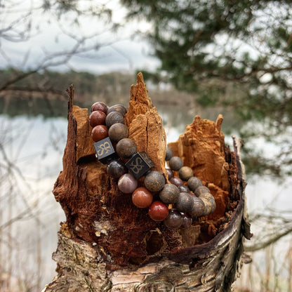 De Autumn Forest Set (8mm) van Stoney Bracelets, met kralen van natuursteen en edelsteen, is op artistieke wijze om een robuuste boomstronk gewikkeld. Het licht vervaagde meer en de omringende bomen op de achtergrond creëren een natuurlijke en serene setting, die de aardse tinten van deze kralenarmband versterkt met een extra vleugje organische schoonheid.