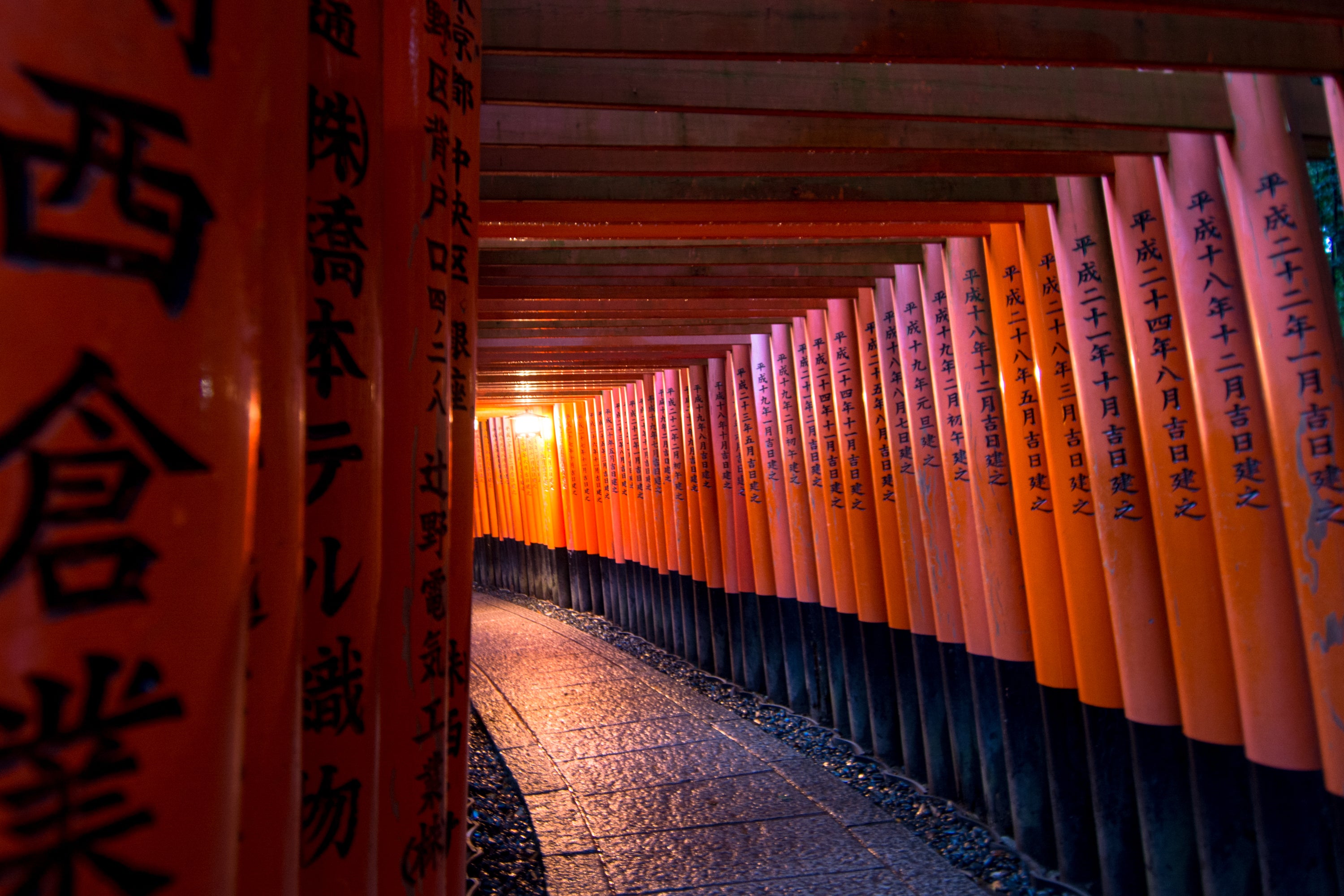 Een gang met oranje tori tori-poorten en Chinese karakters.