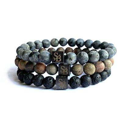 Een set van drie Earth Set (8mm) armbanden gemaakt van grijze en zwarte lavastenen van Stoney Bracelets.