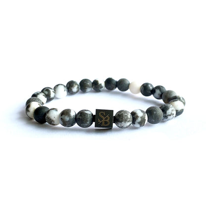 Een armband met Frosted Zebra Stones (8mm) en witte edelsteen, versierd met een klein houten kraaltje van Stoney Bracelets.