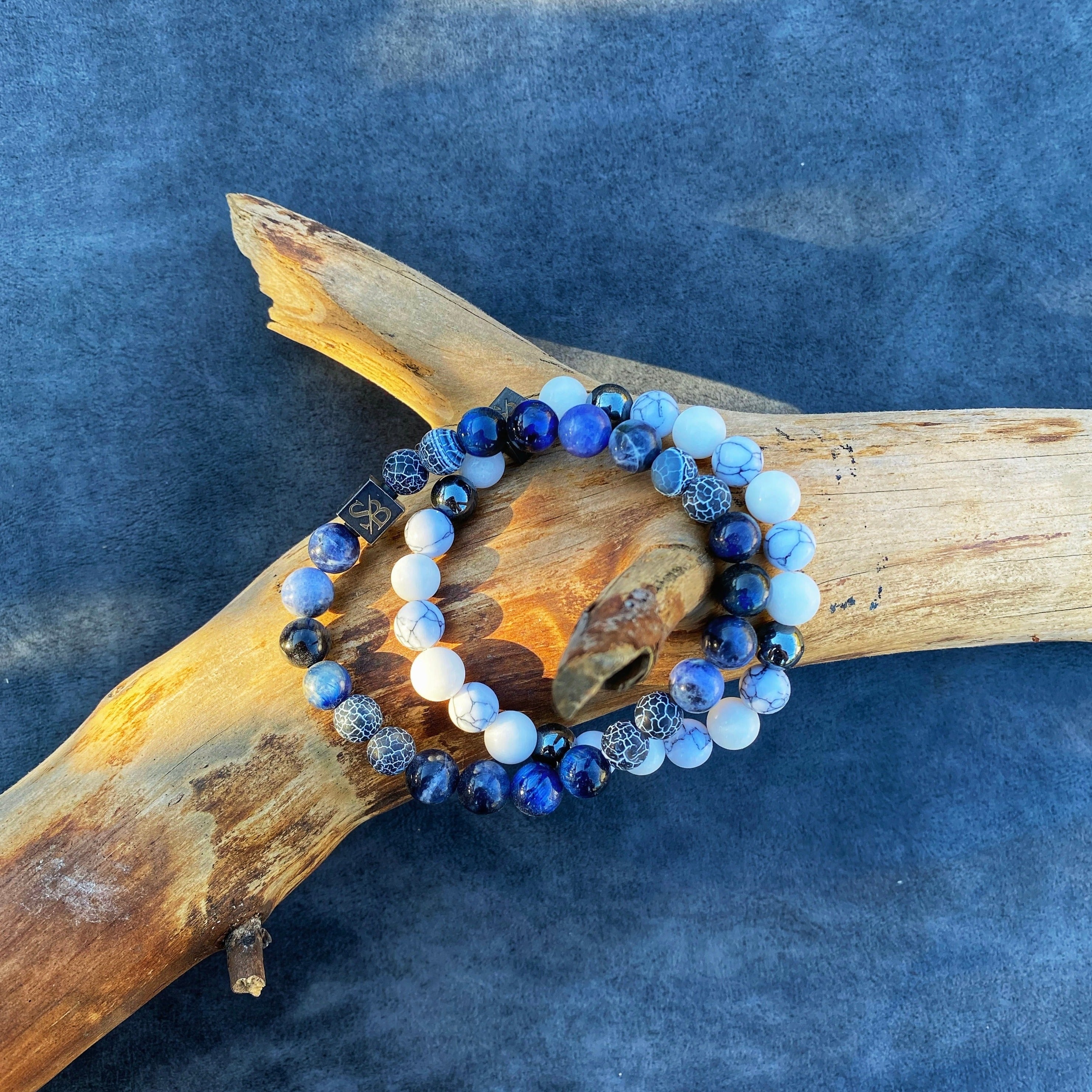 Twee Arctische | Mixed Stones (8mm) armbanden met blauwe en witte natuursteen kralen op boomstam van Stoney Bracelets.