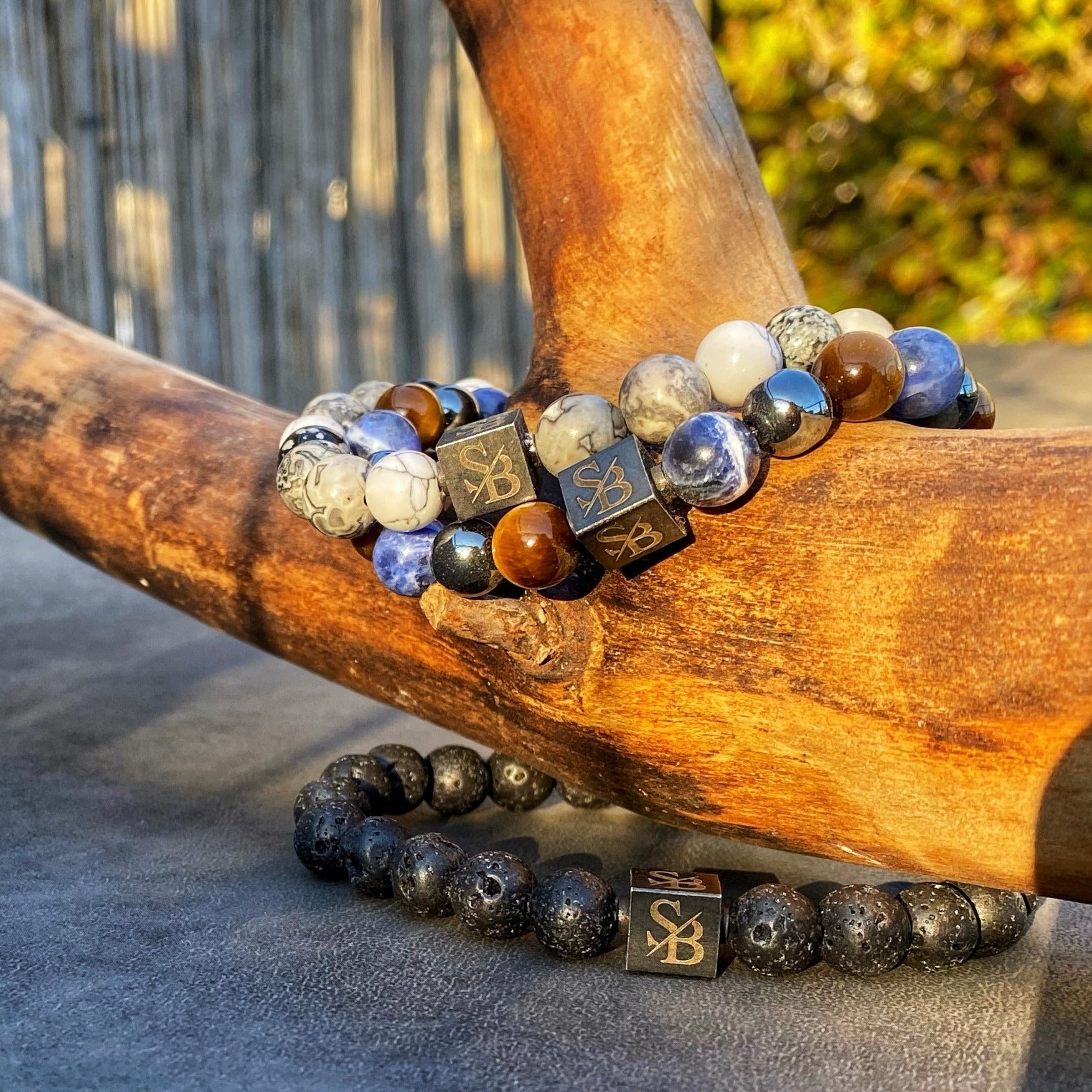 Een armband met Naturel | Gemengde Stenen (8mm) op een houten tak van Stoney Bracelets.