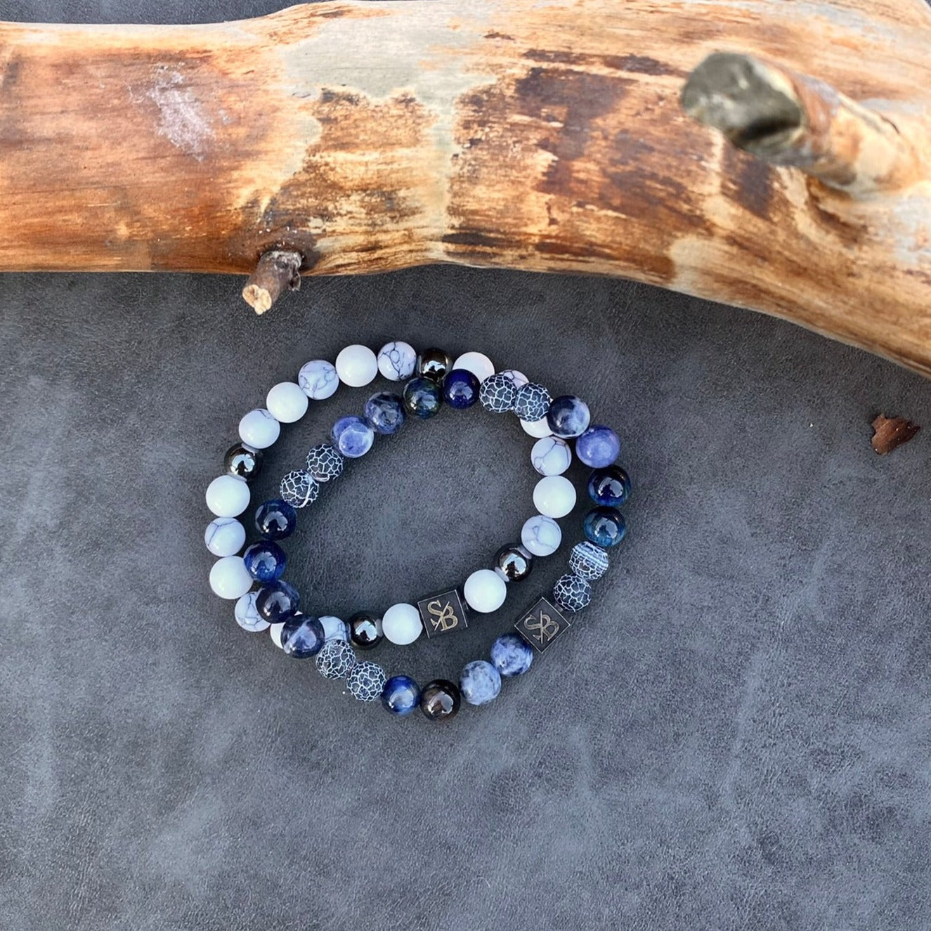 Twee Oceaan | Mixed Stones (8 mm) op de natuur geïnspireerde armbanden met blauwe en zwarte edelsteenkralen op een boomstam van Stoney Bracelets.