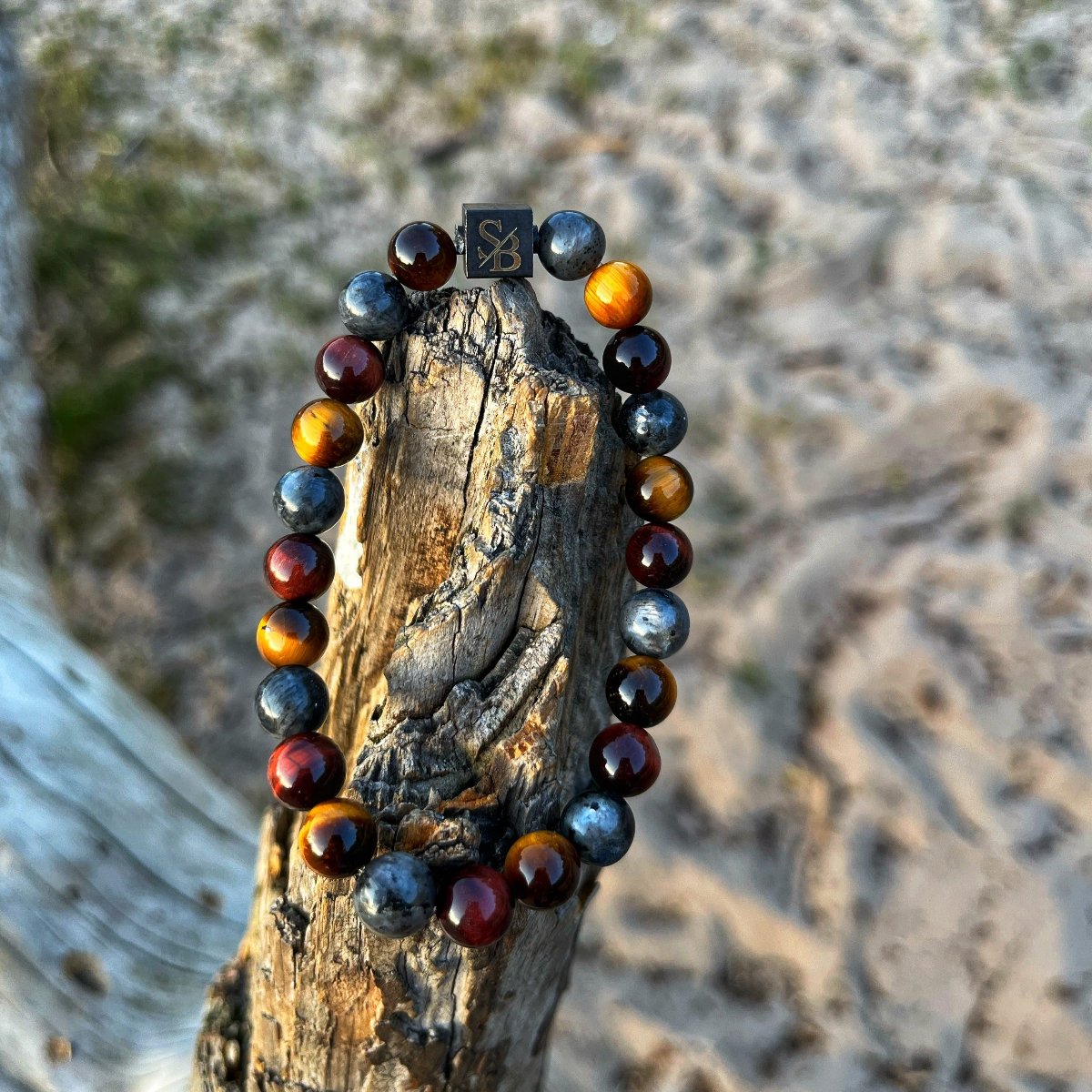 Een Stoney-armband met Firing | Mixed Stones (8mm) kralen op een logboek.