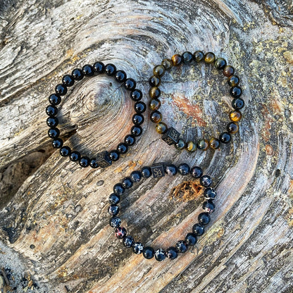 Drie Bandit Set (8mm) armbanden met kralen op een stuk hout van Stoney Bracelets.