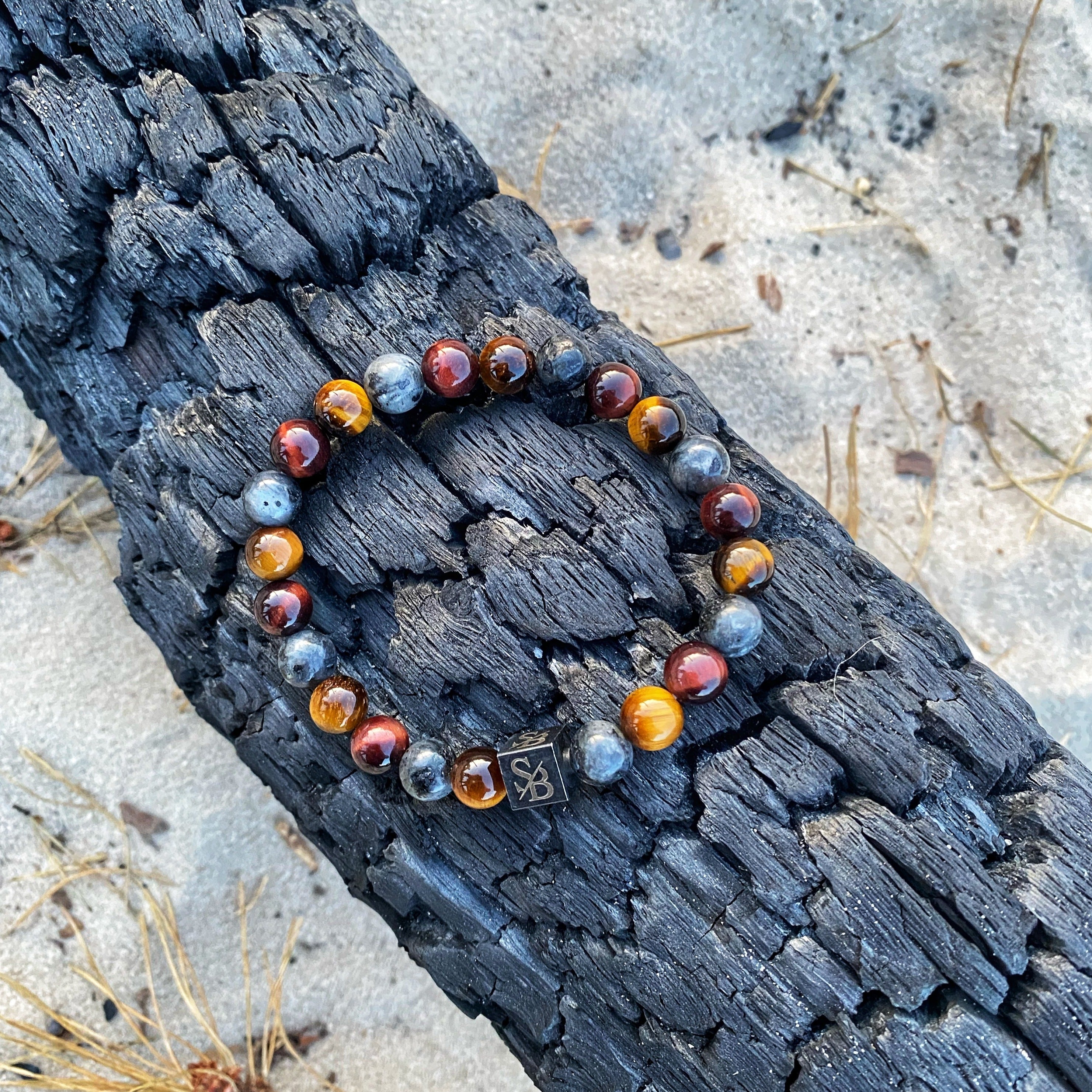 Een Stoney Bracelets armband met Firing | Gemengde stenen (8 mm) kralen bovenop een boomstam, met prachtige kralen.