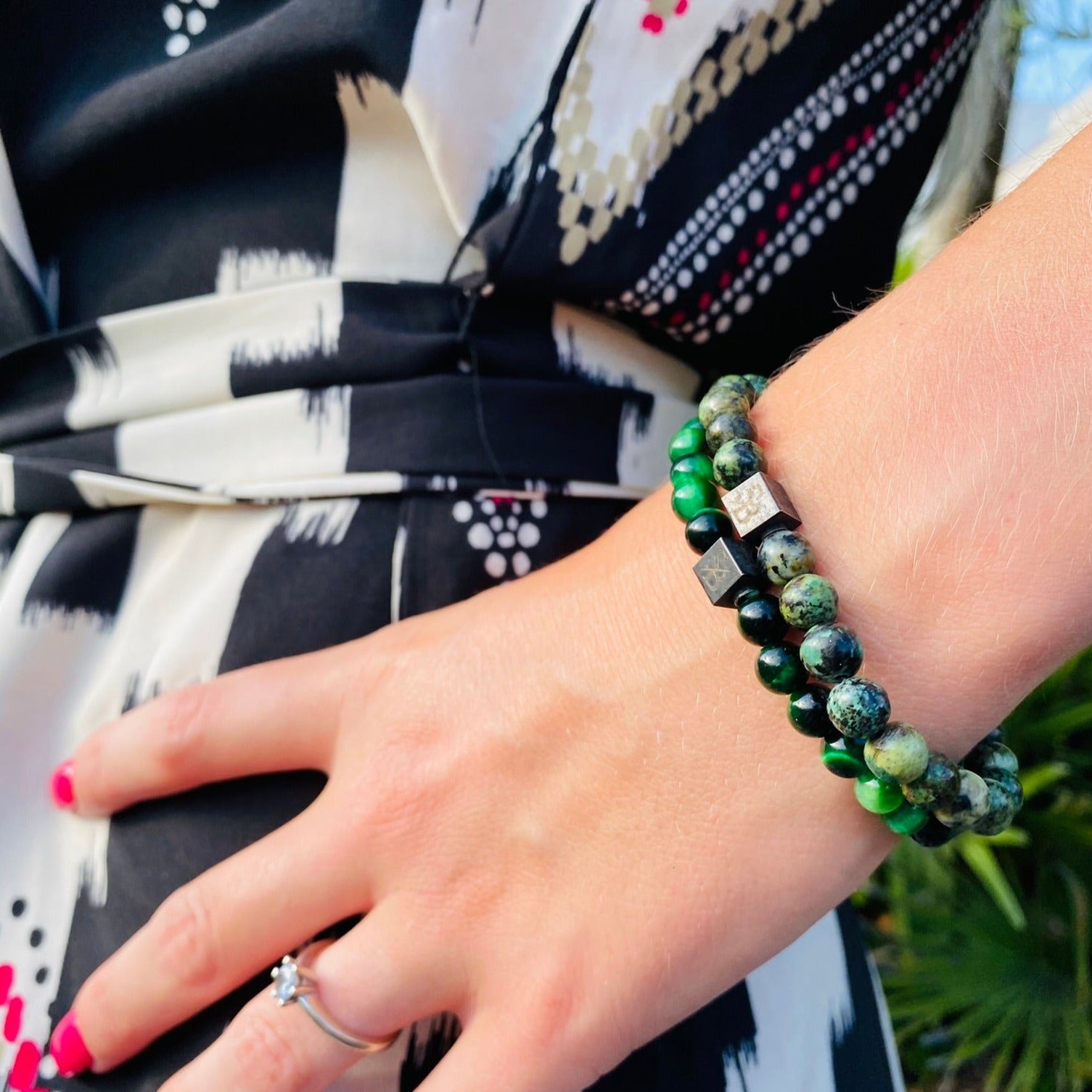 Een vrouw die een groene en zwarte Stoney Bracelets-armband met Afrikaanse turquoise stenen (6 mm) draagt.