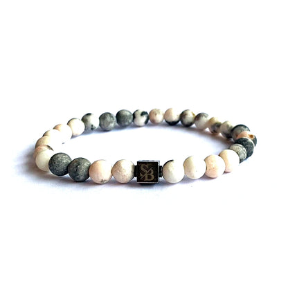 Een Stoney Bracelets armband met Matte Zebra Stenen (6mm) en een zwart-witte kraal.