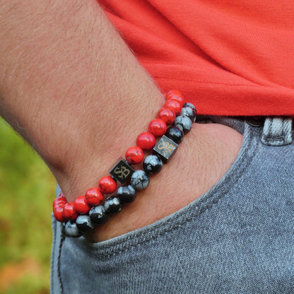 Een man met een Stoney Bracelets Red vs Black Set (8 mm) kralenarmband.