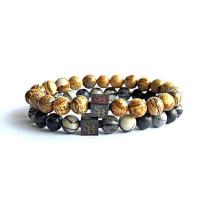 Een paar Saburra Set (8mm) armbanden met tijgeroog kralen en een houten blok van Stoney Bracelets.