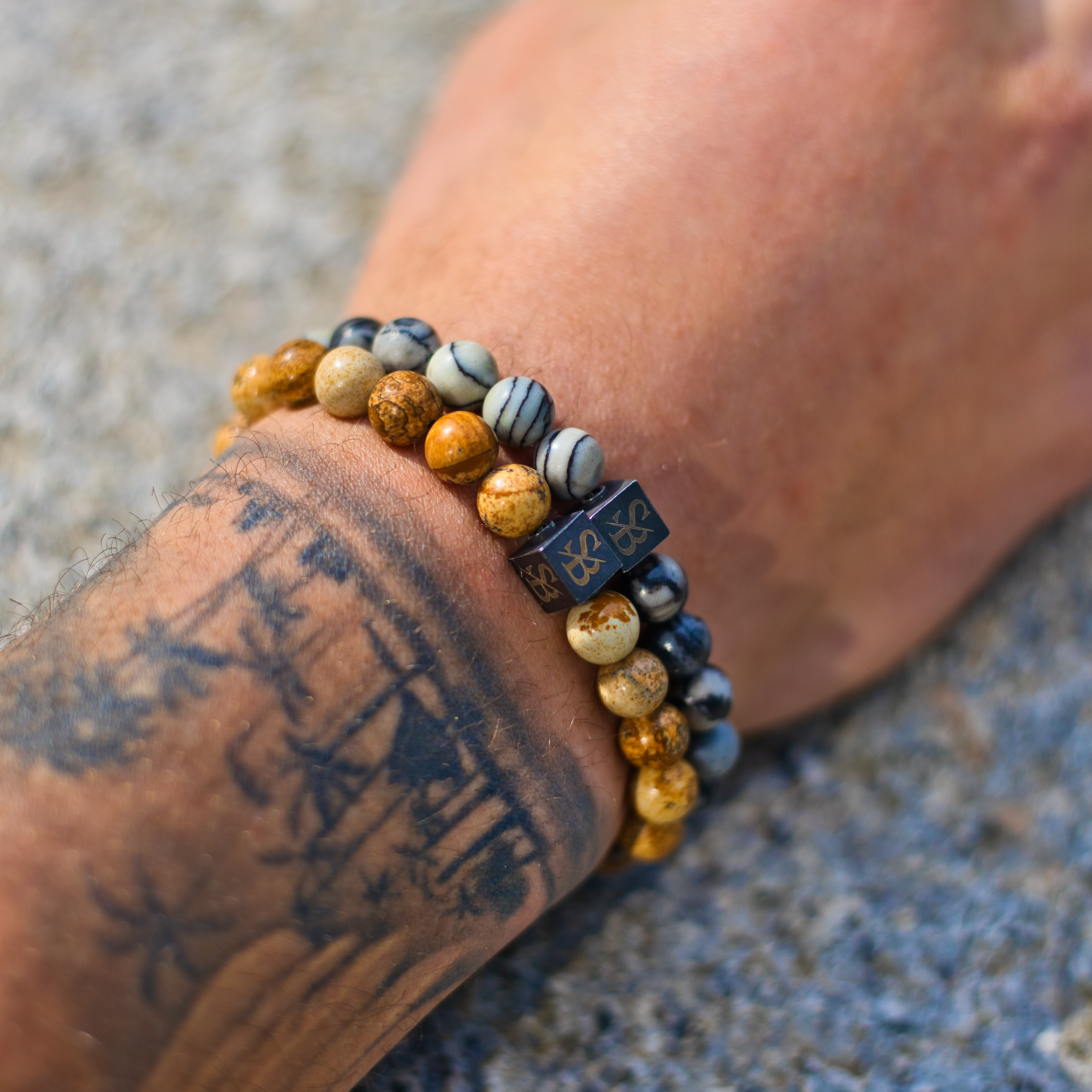 Een persoon die een Saburra Set (8 mm) armband van Stoney Bracelets draagt.