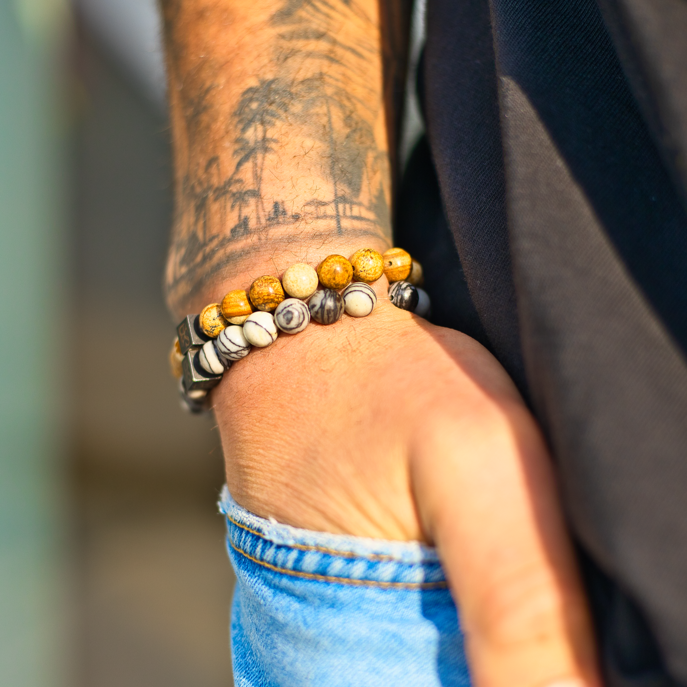 Een man die een Stoney Bracelets Saburra Set (8 mm) armband met kralen om zijn pols draagt.